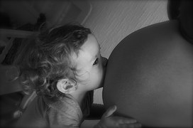 baby kissing pregnant woman's belly